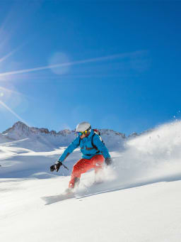 Wintersport: Wintersportler fährt auf einem Snowboard den Hang herunter. Wintersport: Wintersportler fährt auf einem Snowboard den Hang herunter.
