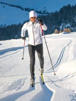 Die schönsten Langlaufgebiete in Österreich: Langläuferin fährt durch Schnee. Die schönsten Langlaufgebiete in Österreich: Langläuferin fährt durch Schnee.