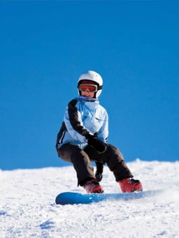 Snowboard Kinder: Junges Mädchen fährt auf ihrem Snowboard einen Hang herunter. Snowboard Kinder: Junges Mädchen fährt auf ihrem Snowboard einen Hang herunter.