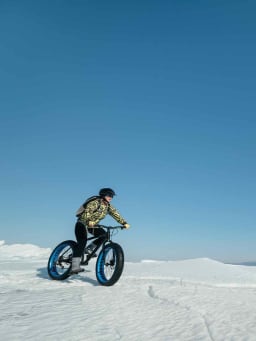 Trendsportarten Winter: Eine Frau fährt mit einem Fatbike durch den Schnee. Trendsportarten Winter: Eine Frau fährt mit einem Fatbike durch den Schnee.