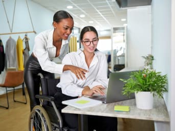 Ausbildung für Menschen mit Behinderung – Auszubildende erhält Hilfe von ihrer Ausbilderin. Ausbildung für Menschen mit Behinderung – Auszubildende erhält Hilfe von ihrer Ausbilderin.