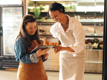 Ausbildung mit Behinderung – Auszubildende hat Spaß bei ihrer Ausbildung im Lebensmittelgeschäft. Ausbildung mit Behinderung – Auszubildende hat Spaß bei ihrer Ausbildung im Lebensmittelgeschäft.