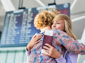 Het plannen van een jaar in het buitenland: moeder en dochter nemen afscheid op de luchthaven.  Het plannen van een jaar in het buitenland: moeder en dochter nemen afscheid op de luchthaven.