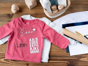 Vorbereitung für das Aufbringen von Schrift auf einen Pullover. Vorbereitung für das Aufbringen von Schrift auf einen Pullover.