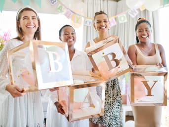 Gruppe von Freundinnen mit selbst gebastelter Babyparty-Deko in Pastellfarben. Gruppe von Freundinnen mit selbst gebastelter Babyparty-Deko in Pastellfarben.