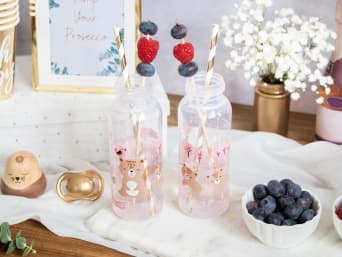 Einfache Mocktails für die Babyparty: Rosa Limonade mit Beeren und Blüten in einer Babyflasche. Einfache Mocktails für die Babyparty: Rosa Limonade mit Beeren und Blüten in einer Babyflasche.