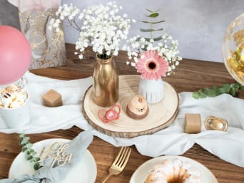 Selbst gestaltete Babyparty-Deko und frische Blumen auf einem Tisch. Selbst gestaltete Babyparty-Deko und frische Blumen auf einem Tisch.