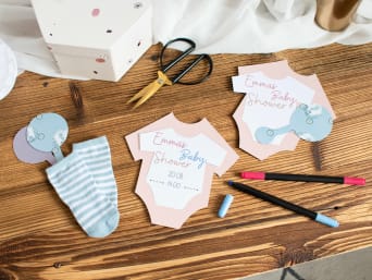 Babyparty Idee: Selbstgebastelte Babyshower-Einladungen mit Babysocken und in Form von Babykleidung. Babyparty Idee: Selbstgebastelte Babyshower-Einladungen mit Babysocken und in Form von Babykleidung.