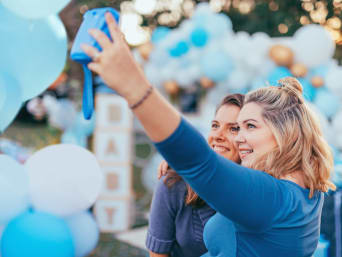 Frauen nehmen Erinnerungsfotos von der Babyparty mit einer Sofortbildkamera auf. Frauen nehmen Erinnerungsfotos von der Babyparty mit einer Sofortbildkamera auf.