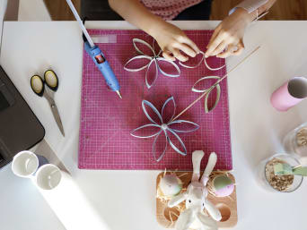 Blumen basteln aus Papier – Kind klebt Papierblumen zusammen. Blumen basteln aus Papier – Kind klebt Papierblumen zusammen.