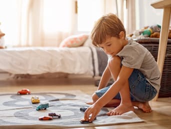 Freies Spiel Kinder – Junge spielt alleine mit Spielzeugautos. Freies Spiel Kinder – Junge spielt alleine mit Spielzeugautos.