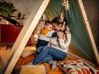 Beschäftigung Kleinkinder: Mutter und Sohne genießen den Nachmittag in einer selbstgebauten Höhle. Beschäftigung Kleinkinder: Mutter und Sohne genießen den Nachmittag in einer selbstgebauten Höhle.