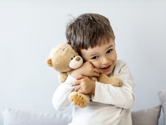 Kinderspielzeug – Junge kuschelt mit seinem Teddy. Kinderspielzeug – Junge kuschelt mit seinem Teddy.