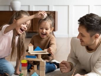 Pädagogisch wertvolles Spielzeug – Familie spielt mit Bauklötzen. Pädagogisch wertvolles Spielzeug – Familie spielt mit Bauklötzen.
