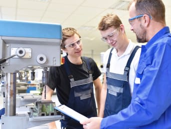 Schülerpraktikum: Lehrer erklärt Praktikanten, wie eine Bohrmaschine funktioniert. Schülerpraktikum: Lehrer erklärt Praktikanten, wie eine Bohrmaschine funktioniert.