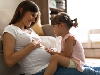 A maternity bra for optimal comfort and support: a pregnant woman spending time with her daughter.  A maternity bra for optimal comfort and support: a pregnant woman spending time with her daughter.