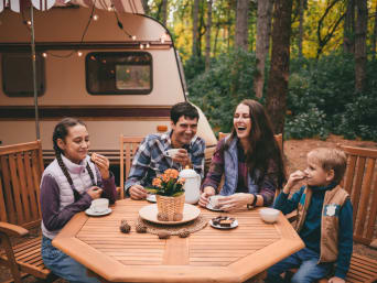 Camping für Anfänger: Familie trinkt zusammen Kaffee auf dem Campingplatz.