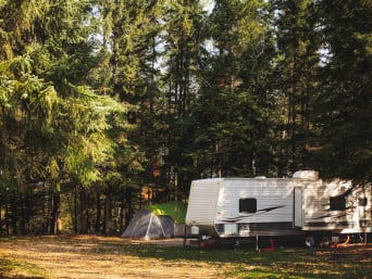 Kamperen in de natuur – Camper en tentje in het bos. Kamperen in de natuur – Camper en tentje in het bos.