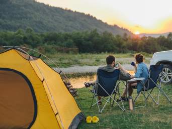 Camping-Tipps für den Zelturlaub: Paar genießt die Zeit in der Natur. 