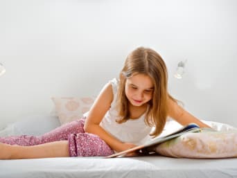 Comics lesen – Mädchen liest einen Comic auf ihrem Bett. Comics lesen – Mädchen liest einen Comic auf ihrem Bett.