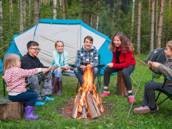 Feriencamp – Kinder grillen Marshmallows über einem Lagerfeuer. Feriencamp – Kinder grillen Marshmallows über einem Lagerfeuer.