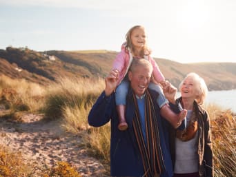 Urlaub mit Oma und Opa: Großeltern und Enkel gehen am Strand spazieren. Urlaub mit Oma und Opa: Großeltern und Enkel gehen am Strand spazieren.