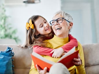 Urlaub mit Großeltern: Oma liest ihrer Enkelin etwas vor.