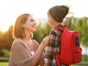 Kinder alleine reisen – Mutter verabschiedet sich von ihrem Sohn.