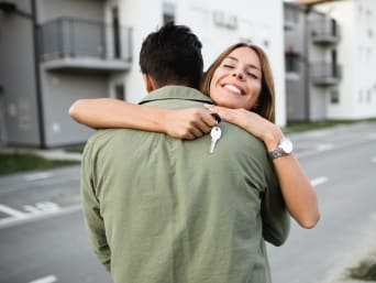 Frau umarmt ihren Partner bei der Wohnungsübernahme. Frau umarmt ihren Partner bei der Wohnungsübernahme.