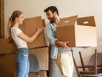 Junges Pärchen beginnt, auszumisten und die Umzugskartons zu packen Junges Pärchen beginnt, auszumisten und die Umzugskartons zu packen