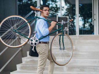 Mit dem Fahrrad zur Arbeit: Mann trägt sein Fahrrad die Stufen hinauf. Mit dem Fahrrad zur Arbeit: Mann trägt sein Fahrrad die Stufen hinauf.
