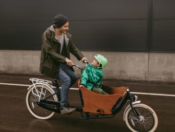 Lastenfahrrad: Vater nimmt seinen Sohn im Lastenfahrrad mit. Lastenfahrrad: Vater nimmt seinen Sohn im Lastenfahrrad mit.