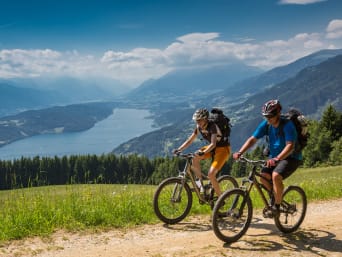 Radtour planen: Zwei Radfahrer fahren oberhalb des Millstätter Sees in Österreich. Radtour planen: Zwei Radfahrer fahren oberhalb des Millstätter Sees in Österreich.