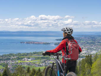 Velotour Bodensee: Frau steht neben ihrem Mountainbike und blickt auf den Bodensee. Velotour Bodensee: Frau steht neben ihrem Mountainbike und blickt auf den Bodensee.