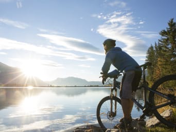 Veloweg Zürich: Mountainbiker genießt Aussicht auf den See. Veloweg Zürich: Mountainbiker genießt Aussicht auf den See.