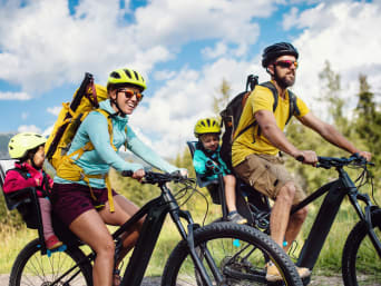Velotour Zug: Familie mit kleinen Kindern fährt auf ihren Velos durch die Natur.  Velotour Zug: Familie mit kleinen Kindern fährt auf ihren Velos durch die Natur.