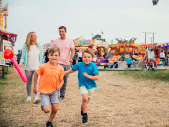 Kinderfestival samen beleven: Familie bezoekt een volksfeest. Kinderfestival samen beleven: Familie bezoekt een volksfeest.