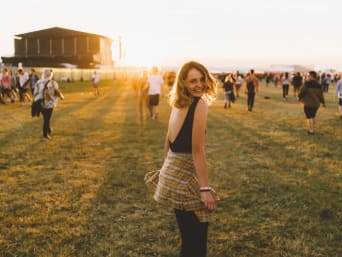 Junge Frau läuft auf einem Open-Air-Festival über das Eventgelände. Junge Frau läuft auf einem Open-Air-Festival über das Eventgelände.