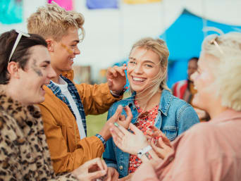 Festival outfits voor dames: Vrienden dragen kleurrijke glitter. Festival outfits voor dames: Vrienden dragen kleurrijke glitter.
