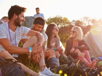 Zonbescherming op festival: groep festivalbezoekers rusten uit in de schaduw. Zonbescherming op festival: groep festivalbezoekers rusten uit in de schaduw.