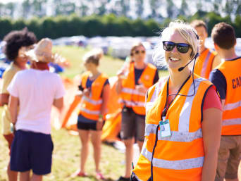 Festivalbeveiliging: festivalpersoneel in opvallende vesten beveiligt het evenement. Festivalbeveiliging: festivalpersoneel in opvallende vesten beveiligt het evenement.