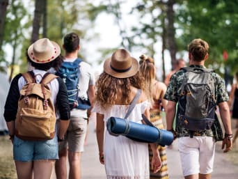 Festival checklist: festivalbezoekers met bagage op weg naar kampeerterrein. Festival checklist: festivalbezoekers met bagage op weg naar kampeerterrein.