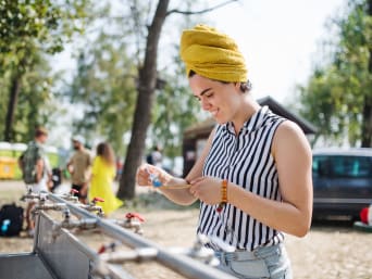 Hygiëne op het festival: jonge vrouw poetst haar tanden aan een wastafel op het festivalterrein. Hygiëne op het festival: jonge vrouw poetst haar tanden aan een wastafel op het festivalterrein.