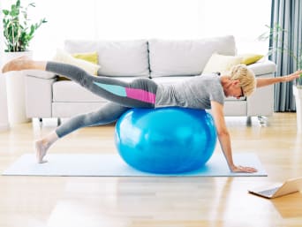 Woman training at home using a gym ball. Woman training at home using a gym ball.