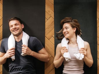 Couple recovering from full-body training at home on fitness mats. Couple recovering from full-body training at home on fitness mats.