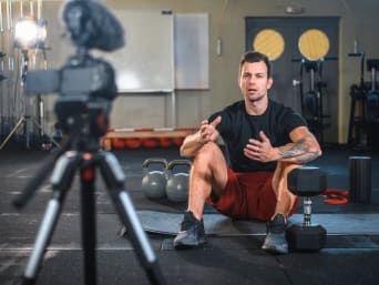 Online gym: Fitness instructor setting up for an online fitness lesson. Online gym: Fitness instructor setting up for an online fitness lesson.