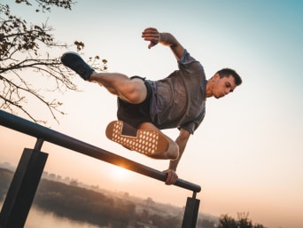 Parcour – man jumping over a railing. Parcour – man jumping over a railing.