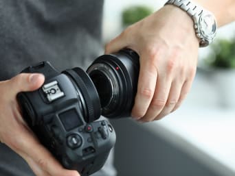 Lenses for beginners – a man is changing the lens on his camera. Lenses for beginners – a man is changing the lens on his camera.