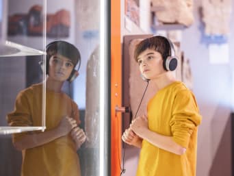 Museum voor kinderen - jongen loopt door de tentoonstelling met een audiogids.