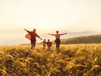 Uitjes met kinderen – Gezin wandelt samen door de natuur bij zonsondergang. Uitjes met kinderen – Gezin wandelt samen door de natuur bij zonsondergang.